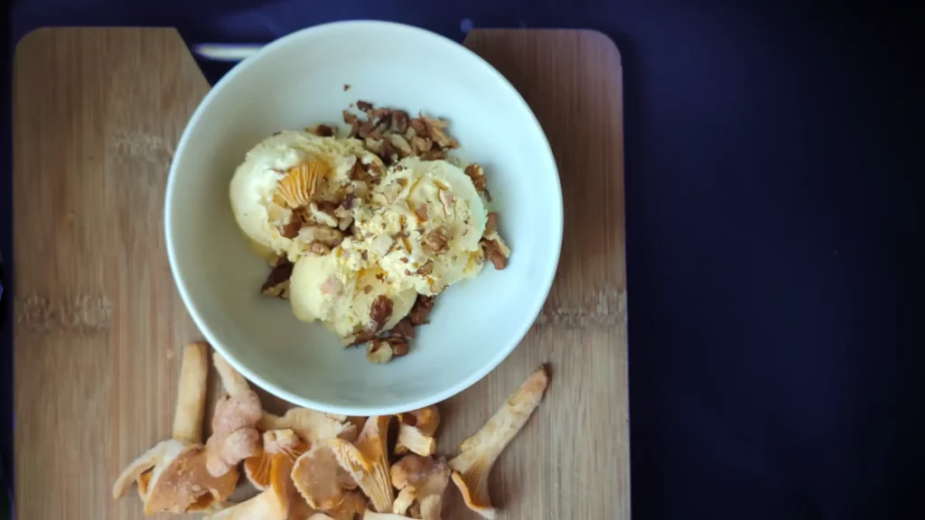 Creamy chanterelle mushroom ice cream served in a white bowl