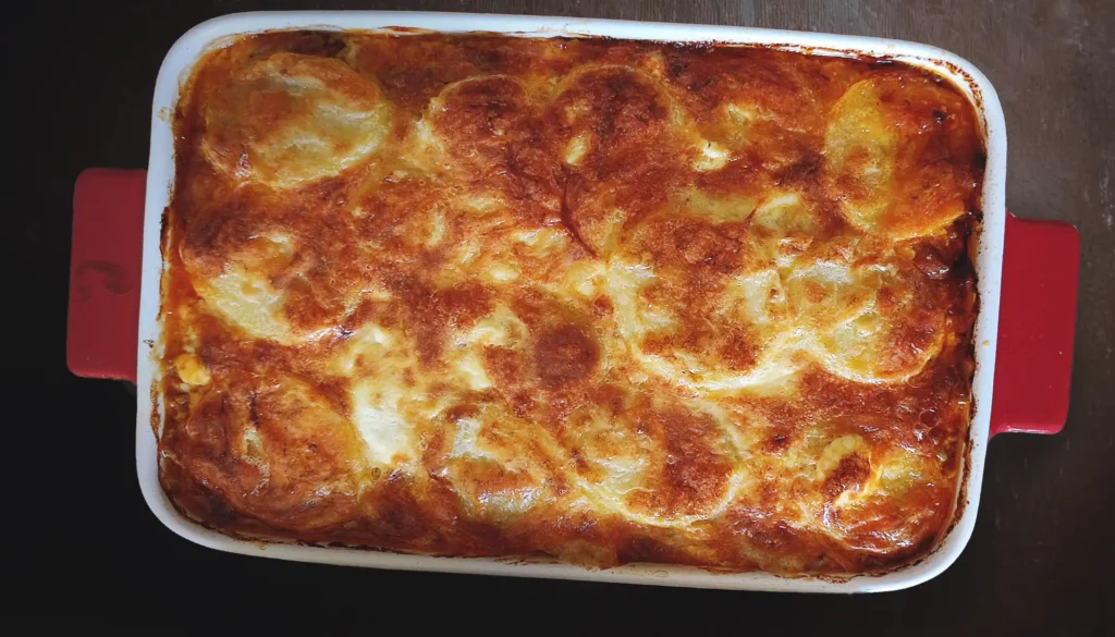 Baked Porcini and Potato Moussaka with Bolognese served in a baking dish