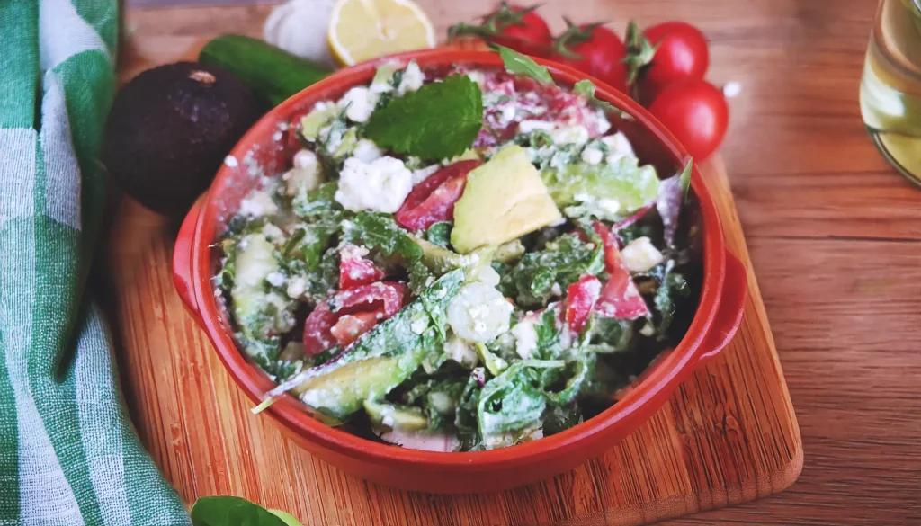 Mediterranean Avocado Feta Salad served in a red bowl