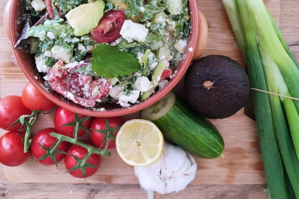 Mediterranean Avocado Feta Salad served in a red bowl