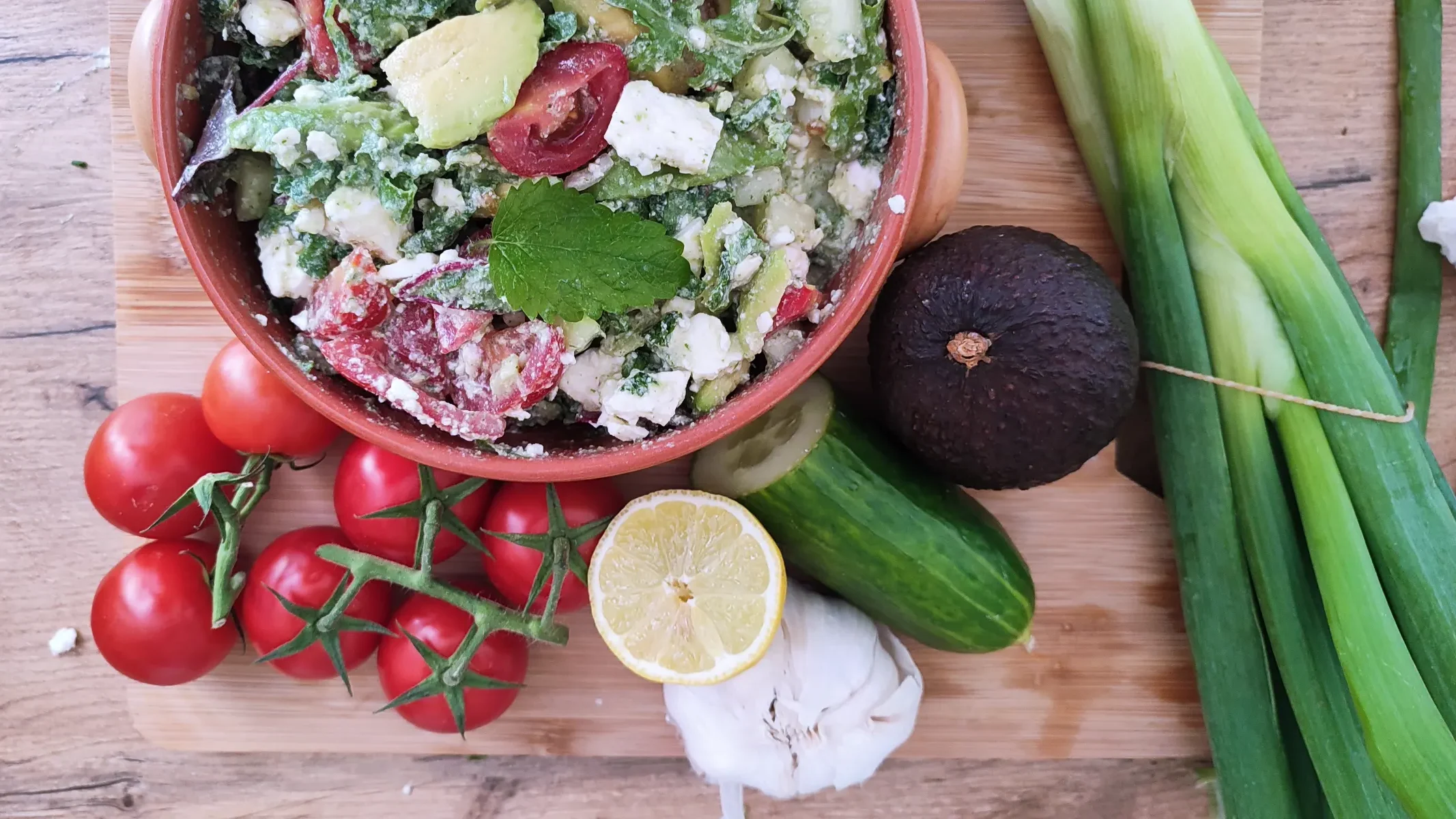 Mediterranean Avocado Feta Salad served in a red bowl